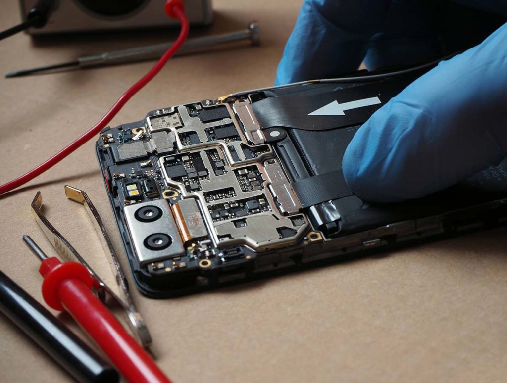 An open smartphone, face down, being prepped for phone data recovery.